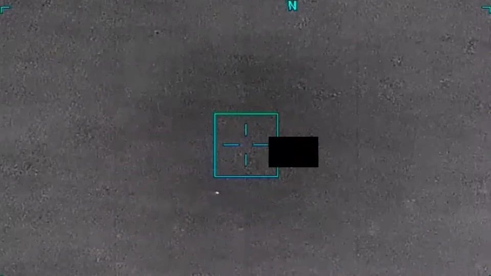 Mar gris en infrarrojo con la retícula azul del sensor en el centro, un bloque negro de censura junto a ella y, abajo a la izquierda, un punto blanco diminuto.