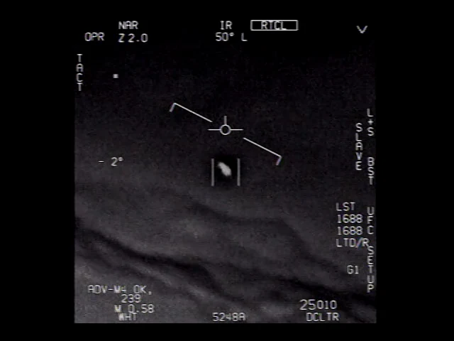 Pantalla infrarroja: un objeto claro entre corchetes sobre una capa de nubes.